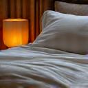 A cozy, well-made bed with soft lighting, indicating restful sleep.